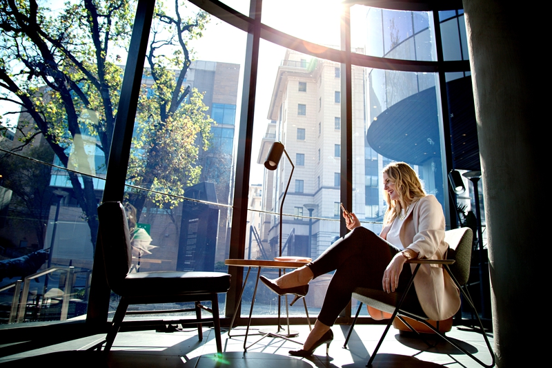 Business woman checking her phone while sitting at Starbucks