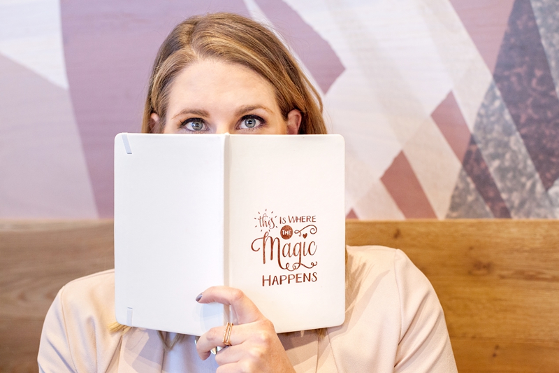 Pam Newman looking over journal titled this is where the magic happens