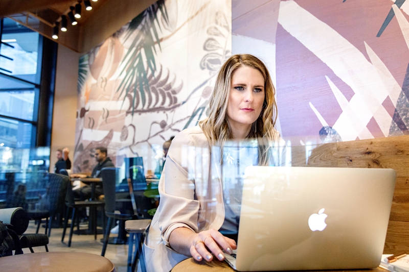 Pam Newman working on an Apple computer at Starbucks