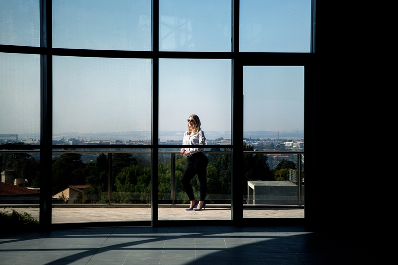 Pam Newman through a window with the city view