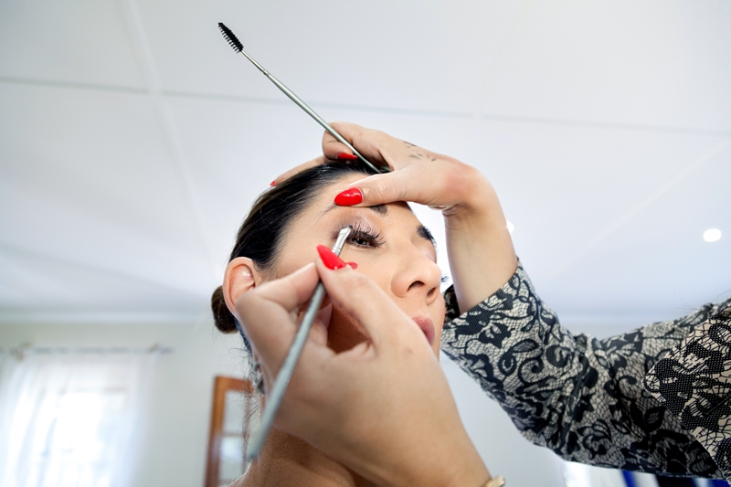 Bride having her makeup done by someone with red nails at the Estuary Hotel, Port Edward.