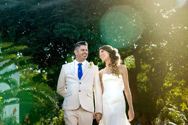 Bride laughing while walking with groom in afternoon light, at the Estuary Hotel, Port Edward.