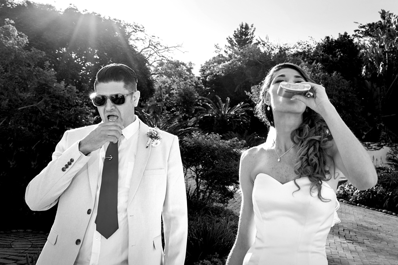 Bride drinking tequila out of a hip flask, groom pulling funny face, at the Estuary Hotel, Port Edward.