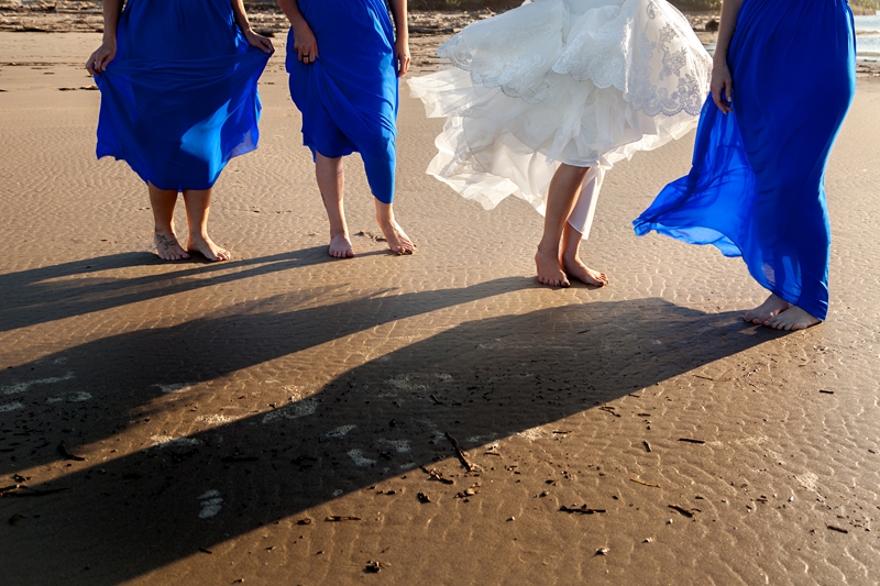 Bridesmaids wearing blue dresses, with their feet in the sand, at the Estuary Hotel, Port Edward