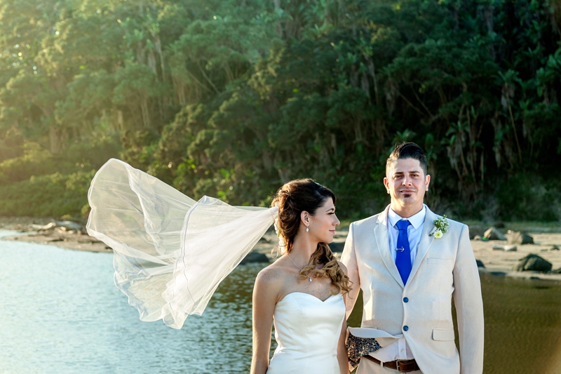 Brides veil flying in the wind, on the beach with the groom next to her, during afternoon light at the Estuary Hotel, Port Edward.