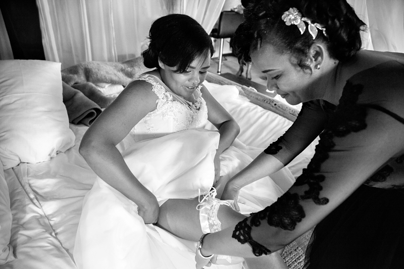 Black and white photograph, Bride putting on garter at Valverde Eco Hotel.