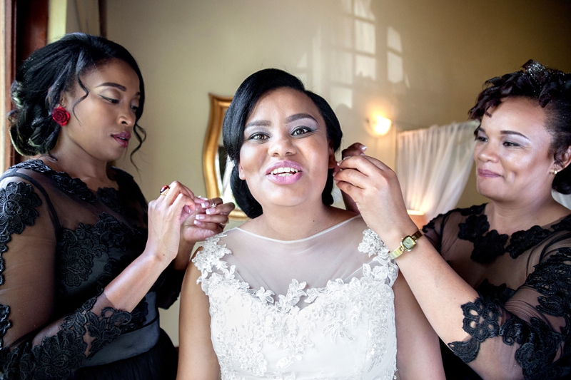 Bridesmaids putting brides earrings on at Valverde Eco Hotel.