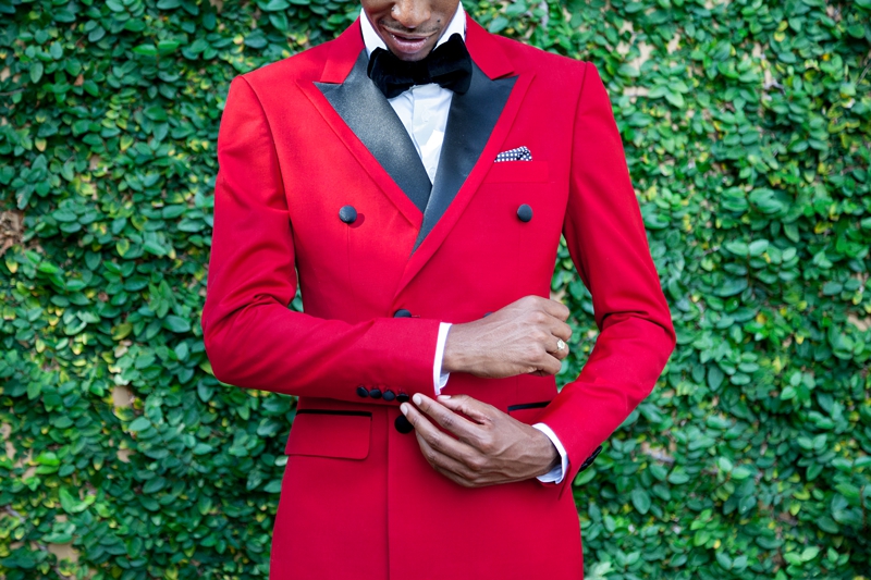 Groom, wearing red jacket, standing in front of a green wall at Valverde Eco Hotel.