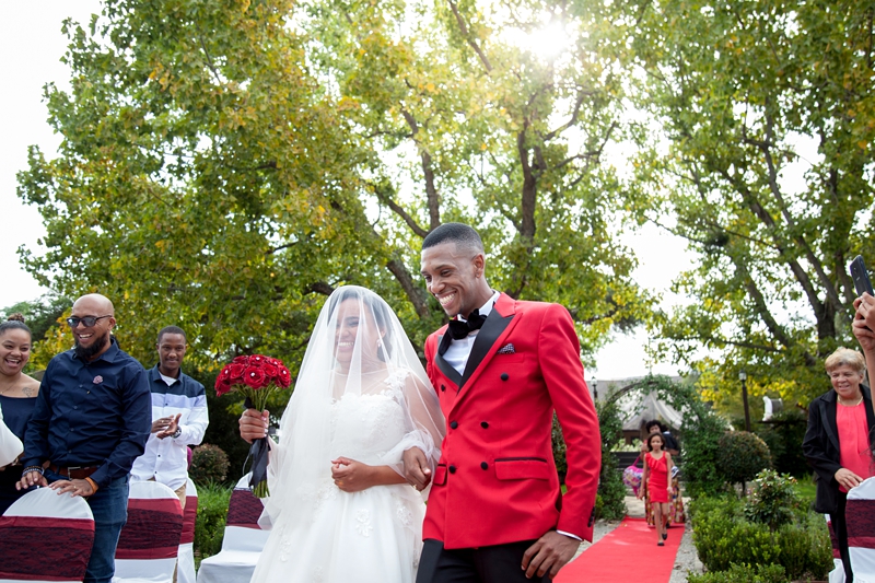 Bride and groom laughing while walking down the isle at Valverde Eco Hotel.
