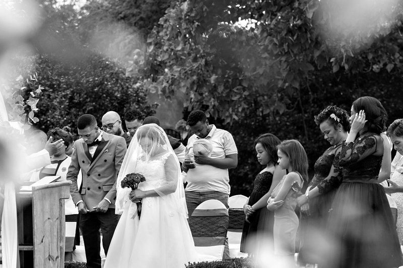 Black and white photograph, bride and groom praying during ceremony at Valverde Eco Hotel.