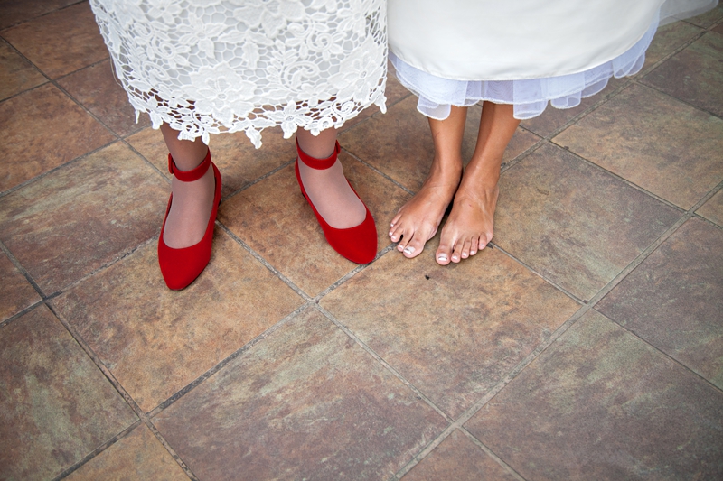 Barefoot bride next to red shoes at Valverde Eco Hotel.