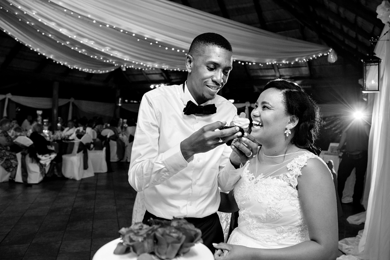Black and white photograph, groom feeding bride a cupcake at Valverde Eco Hotel.