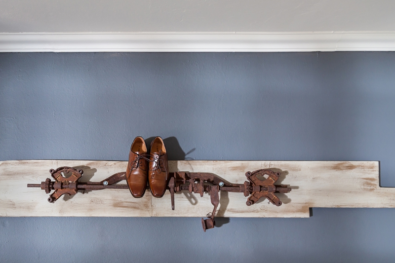 Brown shoes on old farm equipment hanging on the wall at Valverde Eco Hotel.