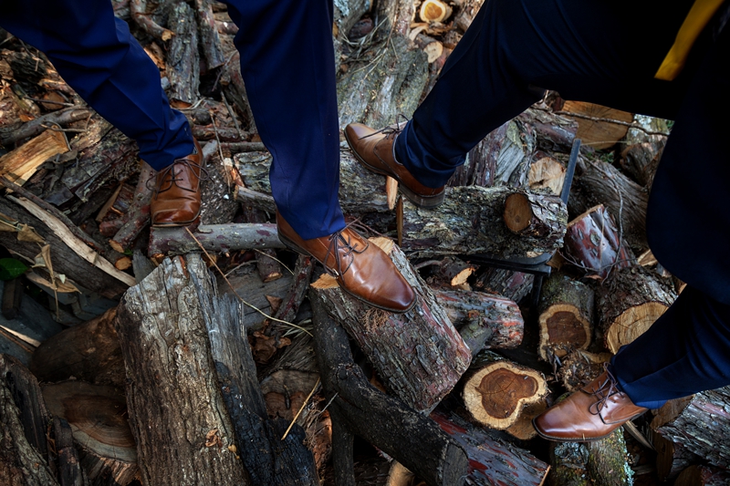 Grooms brown shoes on cut wood logs at Valverde Eco Hotel.