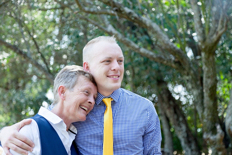 Groom wearing yellow tie, hugging mom at Valverde Eco Hotel.