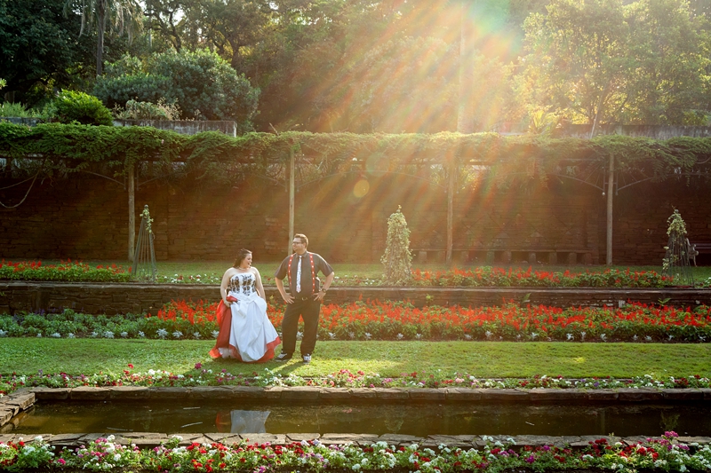 Alice in Wonderland themed bride and groom posing in Durban Botanical Gardens during afternoon light