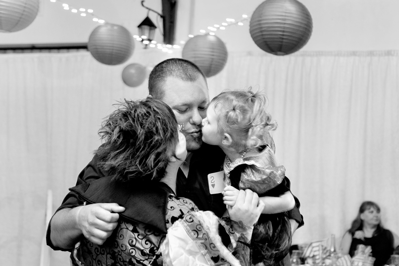 Mom, dad, and child giving each other a kiss.