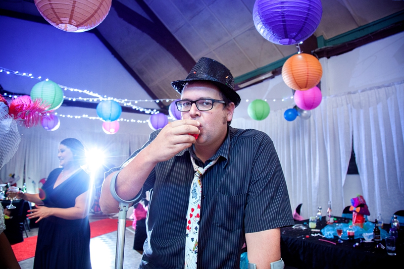 Groom drinking shot at Alice in Wonderland themed wedding.