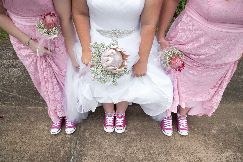 Protea bouquets and pink Converse wedding shoes.