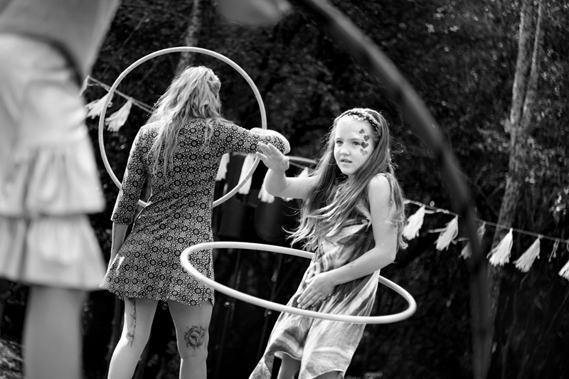Young girl with long hair, playing with hula hoop during Hippie Fest, at the Forest Venue.