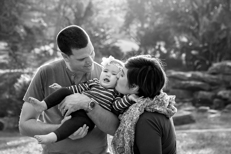 Parents trying to cheer up grumpy girl toddler at Japanese Gardens, Pinetown.