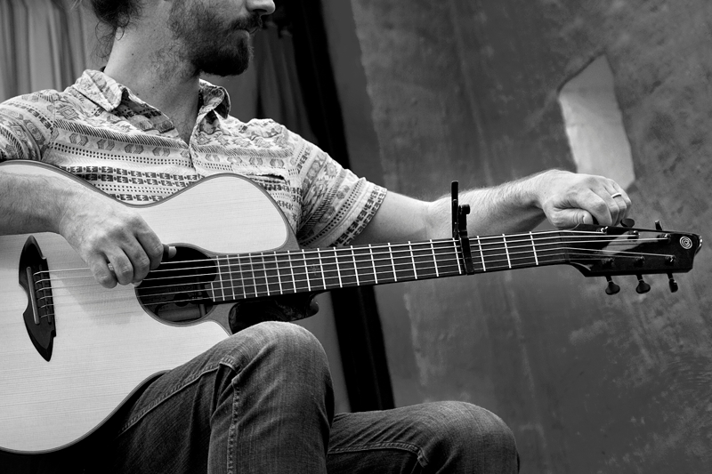 Guy Buttery, South African musician tuning his guitar, at Klitsgras Drumming valentines picnic.
