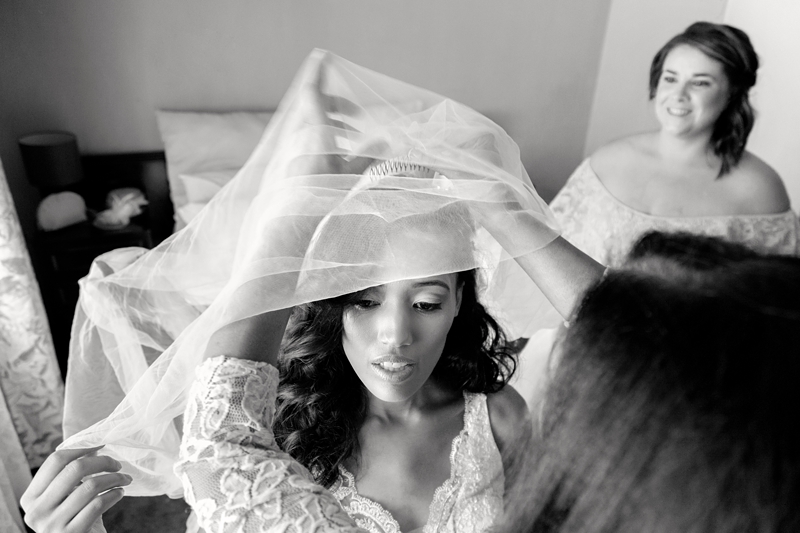 Mother of the bride helping the bride with the long veil.