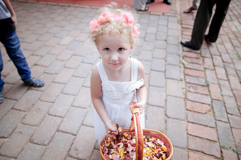 Flower girl holding basket of rose petals at Leafy green Cafe.
