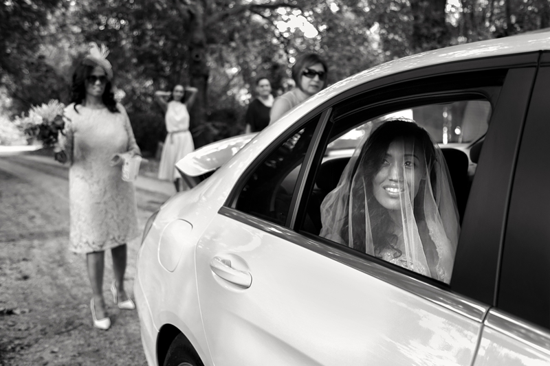 Bride looking out car window at Leafy Green cafe.