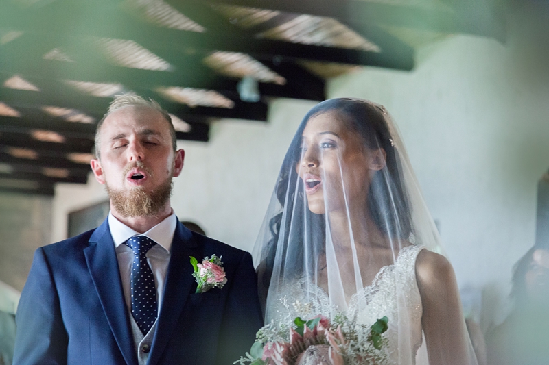 Bride and groom singing during wedding ceremony at Leafy Green Cafe.