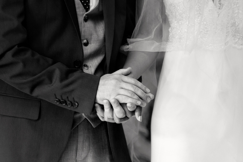 Bride and groom holding hands during ceremony at Leafy Green Cafe.
