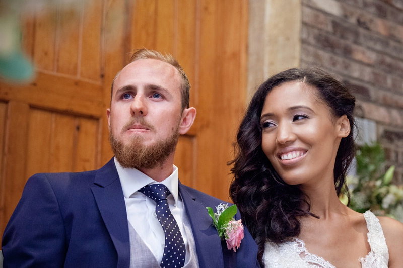 Bride smiling at groom during speeches, at Leafy Green Cafe