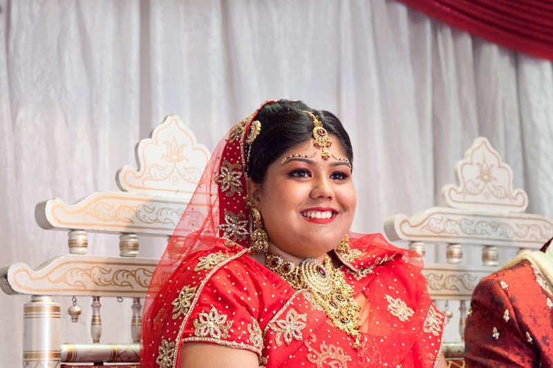 Bride smiling during Hindu ceremony at Shree Radhe Shyam Mandir.