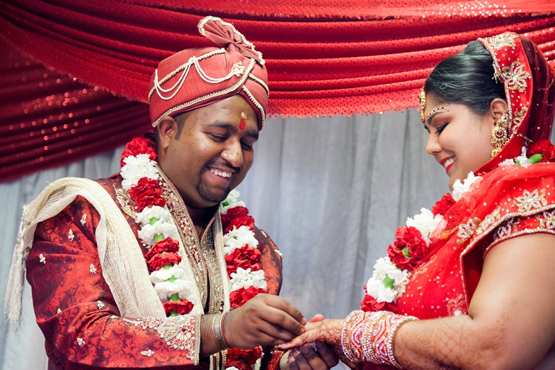 Bride and groom laughing during Hindu ceremony at Shree Radhe Shyam Mandir.
