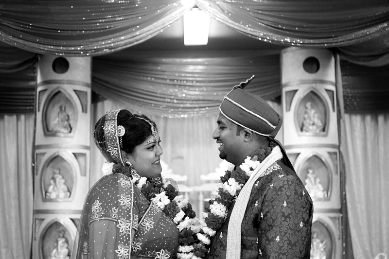 Bride and groom laughing at each other during Hindu ceremony at Shree Radhe Shyam Mandir.
