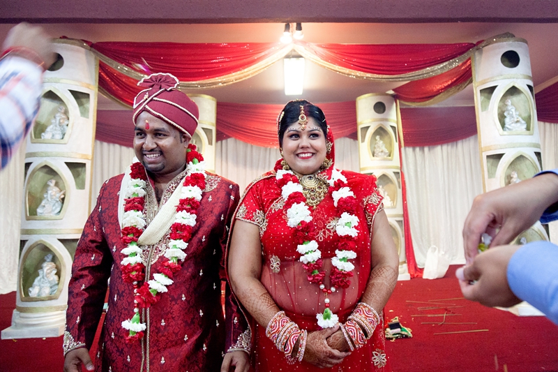 Bride and groom laughing during Hindu ceremony at Shree Radhe Shyam Mandir.