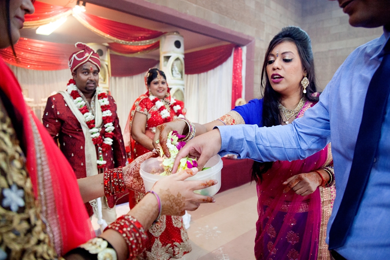 Guests collecting rose petals at Hindu ceremony at Shree Radhe Shyam Mandir.