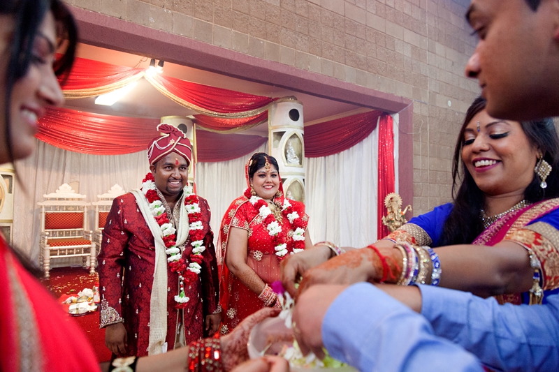 Bride and groom laughing during Hindu ceremony at Shree Radhe Shyam Mandir.