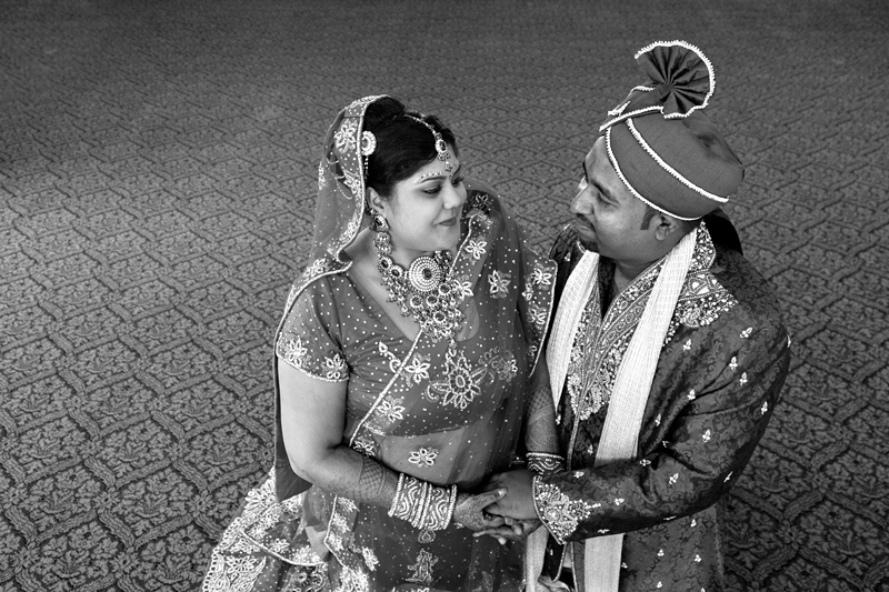 Bride and groom smiling at each other at Shree Radhe Shyam Mandir.