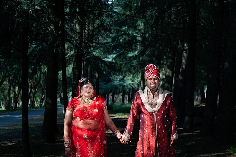 Bride and groom wearing traditional Hindu wedding outfit, with forest background at Field and Study Centre.