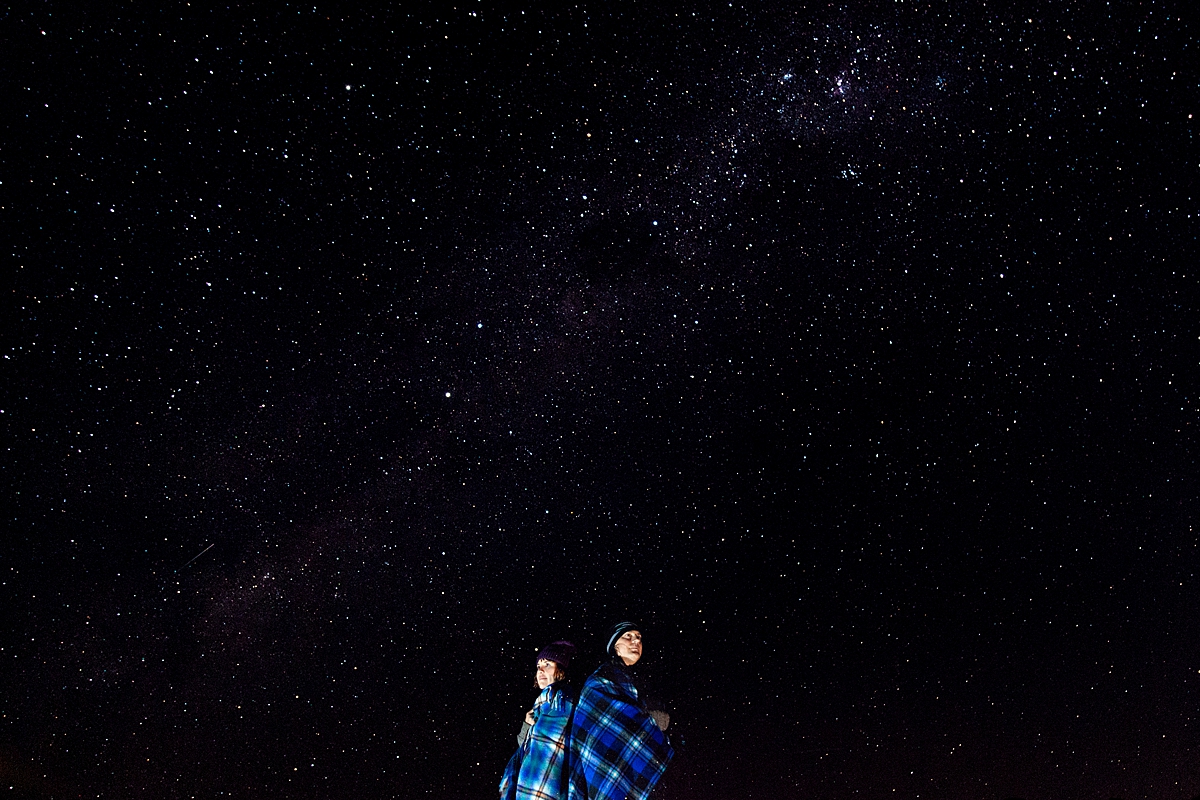 Man and lady wrapped up in blue blankets under the Milkyway in Magoebaskloof